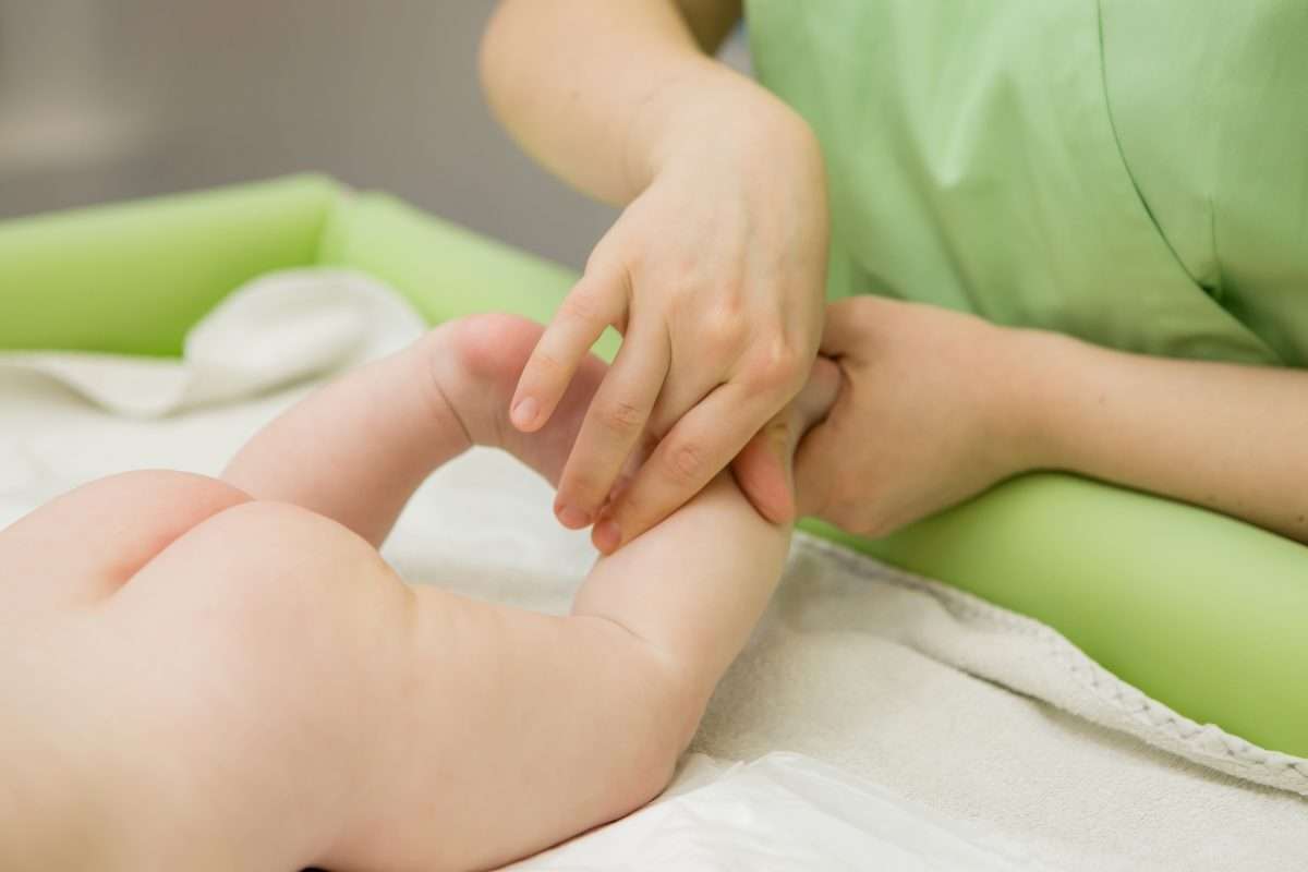 一位准备进入 IVF 周期的女性正在接受针灸调理,针灸师在下腹部与腰骶部精准取穴,以提升助孕效果。